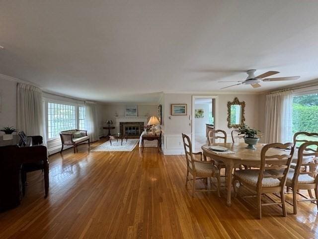 18 Lily Pond Dr, Yarmouth, MA 02664 - dining area featuring wood finished floors, a glass covered fireplace, a ceiling fan, and crown molding