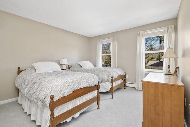 bedroom with light carpet, a baseboard radiator, and baseboards