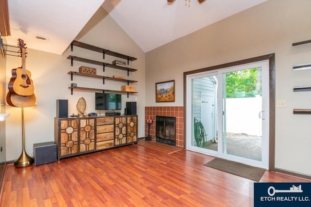 199 Lake St Unit 26, Weymouth, MA 02189 - unfurnished living room featuring wood finished floors, vaulted ceiling, a tile fireplace, and ceiling fan