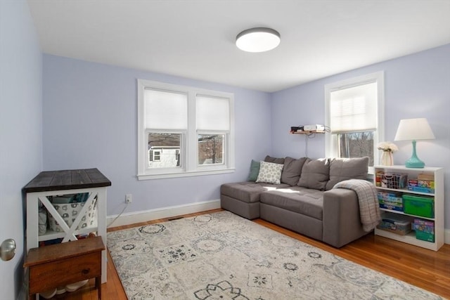 living area featuring baseboards and wood finished floors