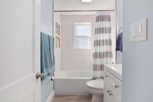 full bathroom featuring vanity, shower / bath combo with shower curtain, wood finished floors, and toilet