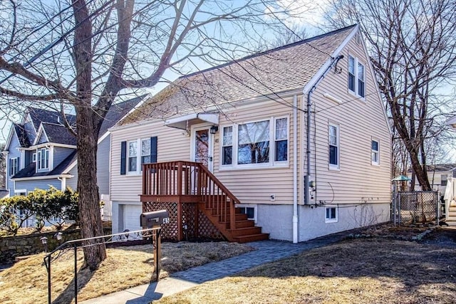 view of front of property featuring roof with shingles, an attached garage, and fence