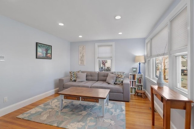 living area with light wood-style flooring, baseboards, and recessed lighting