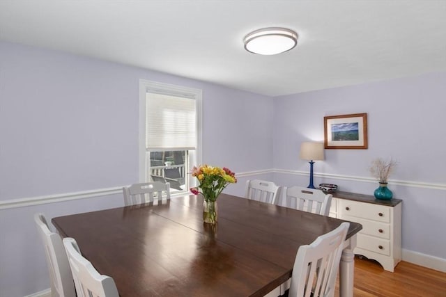 dining space with baseboards and light wood-style floors