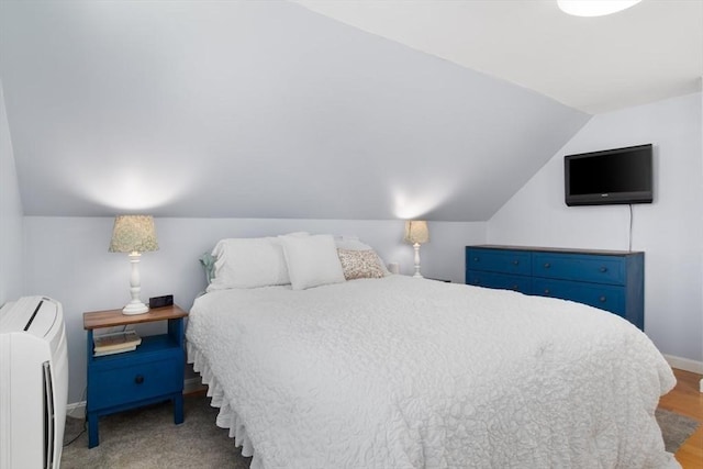 bedroom featuring lofted ceiling and baseboards