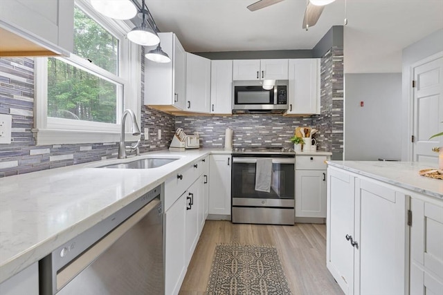 224 Church, Pembroke, NH 03275 - kitchen featuring appliances with stainless steel finishes, tasteful backsplash, light wood finished floors, and white cabinetry