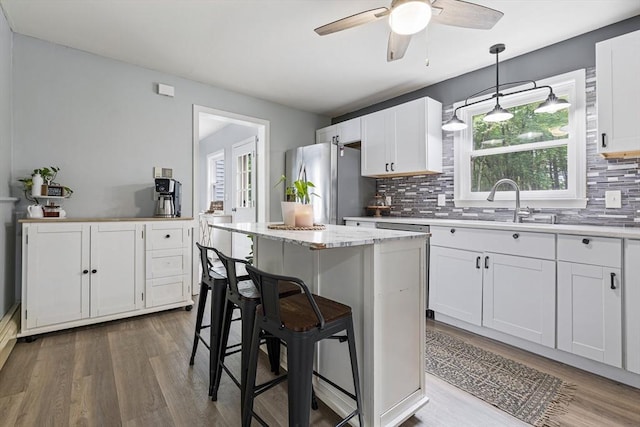 224 Church, Pembroke, NH 03275 - kitchen with freestanding refrigerator, wood finished floors, white cabinets, and tasteful backsplash