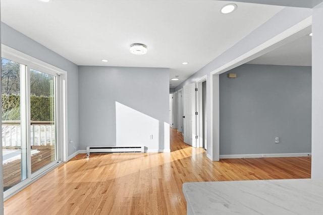 unfurnished room featuring light hardwood / wood-style floors and a baseboard heating unit