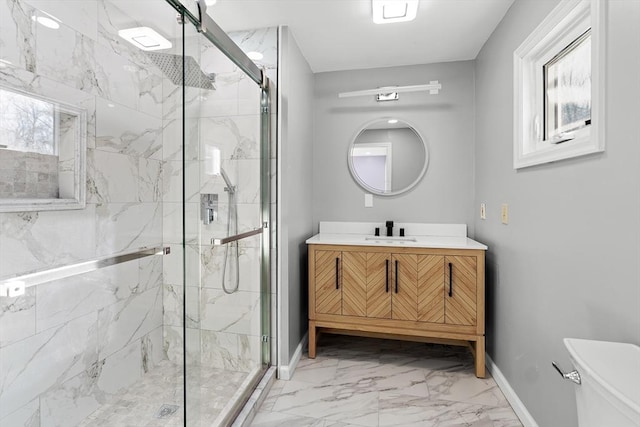 bathroom featuring vanity, toilet, a shower with door, and plenty of natural light