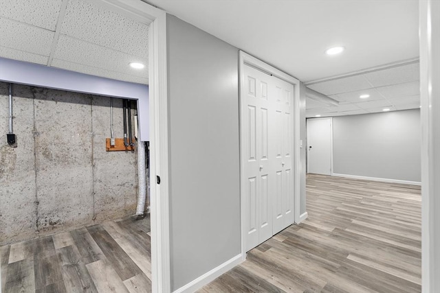 basement with hardwood / wood-style flooring and a paneled ceiling