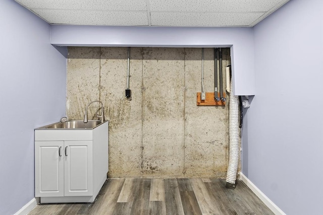 bathroom with a drop ceiling, wood-type flooring, and sink