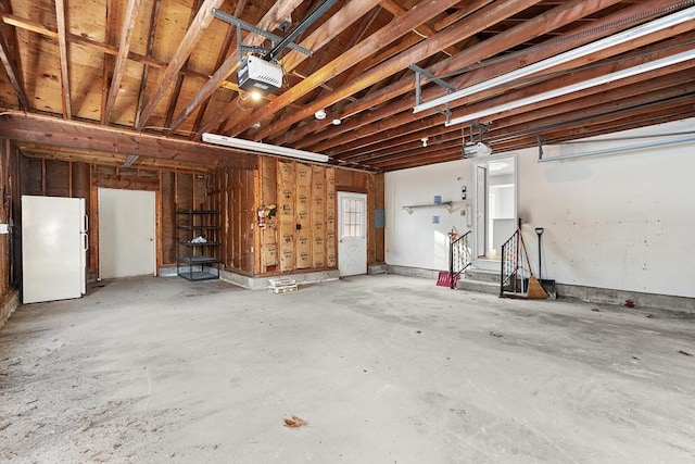 garage featuring white refrigerator and a garage door opener