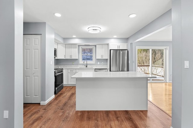 kitchen with a center island, dark wood-type flooring, white cabinets, and stainless steel appliances