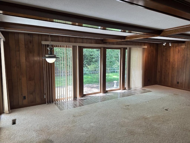 96 Wild Grove Ln, Longmeadow, MA 01106 - unfurnished living room featuring wooden walls, carpet floors, beamed ceiling, and a textured ceiling