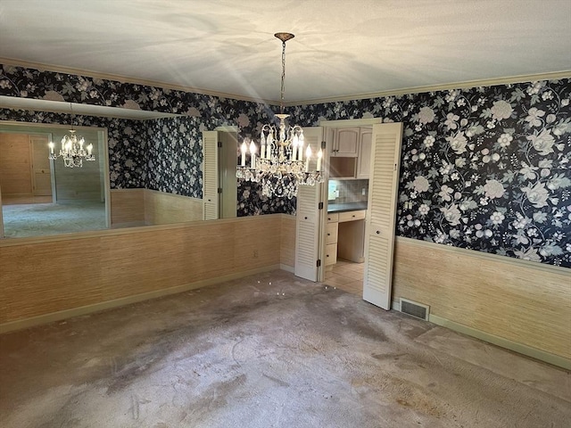 96 Wild Grove Ln, Longmeadow, MA 01106 - unfurnished dining area with a chandelier, wallpapered walls, crown molding, a wainscoted wall, and carpet flooring