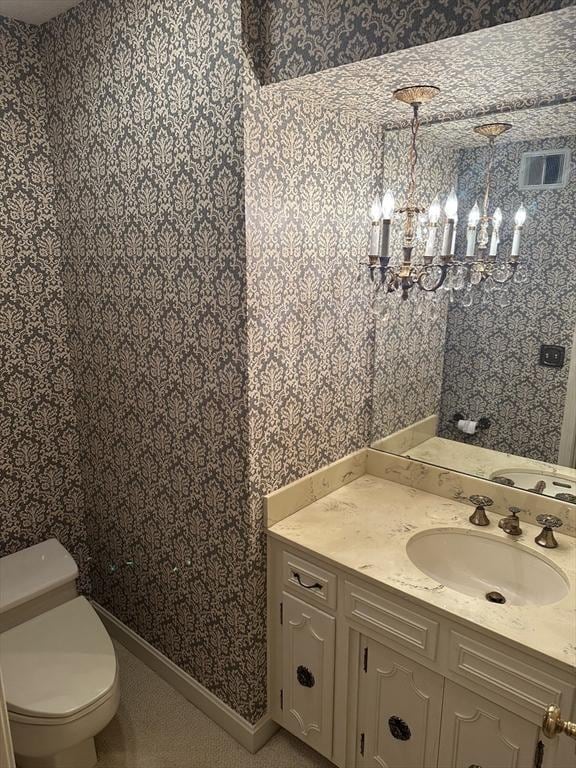 96 Wild Grove Ln, Longmeadow, MA 01106 - bathroom with wallpapered walls, vanity, toilet, and a chandelier