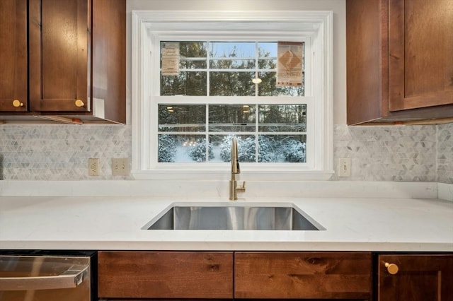 kitchen with dishwasher, sink, backsplash, and light stone counters