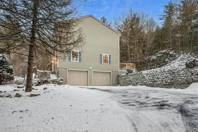 view of snow covered exterior with a garage