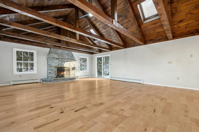 unfurnished living room with wood ceiling, a baseboard radiator, and a stone fireplace