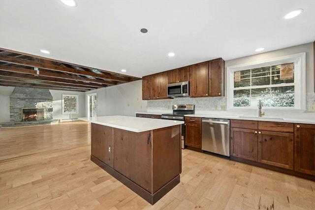 kitchen featuring light hardwood / wood-style flooring, sink, a kitchen island, and appliances with stainless steel finishes