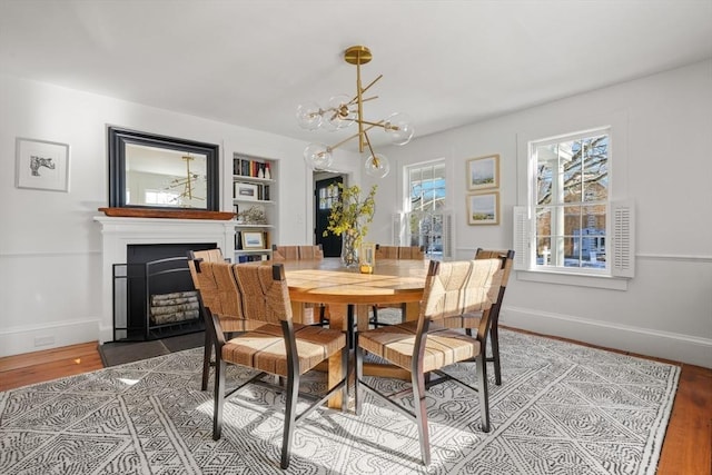 dining space with an inviting chandelier, hardwood / wood-style floors, and built in features