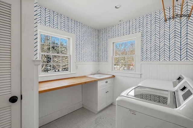 clothes washing area featuring sink, cabinets, and independent washer and dryer