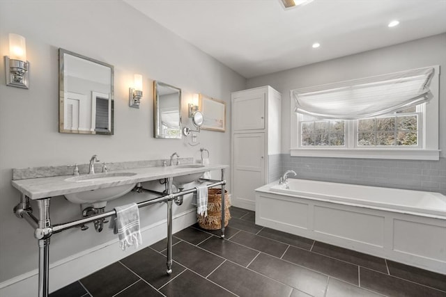 bathroom featuring tile patterned flooring, a bath, and double sink