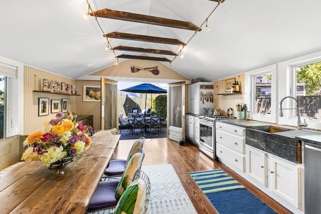 kitchen with dark wood-type flooring, sink, vaulted ceiling with beams, plenty of natural light, and stainless steel appliances