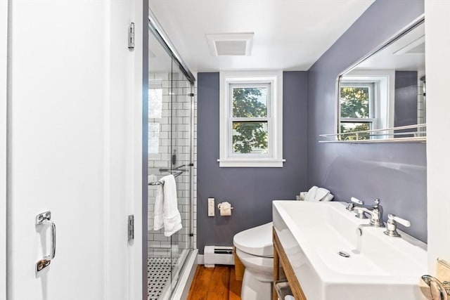 bathroom featuring sink, a baseboard heating unit, hardwood / wood-style floors, an enclosed shower, and toilet