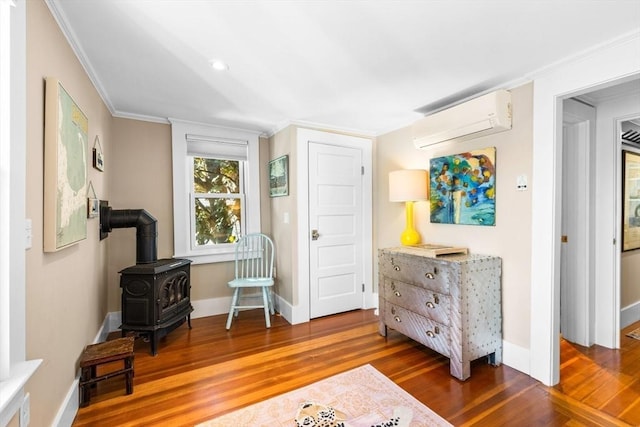 living area featuring dark hardwood / wood-style flooring, crown molding, a wall unit AC, and a wood stove