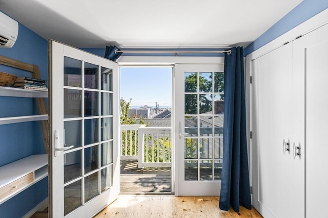 entryway featuring a wall mounted air conditioner and light hardwood / wood-style floors