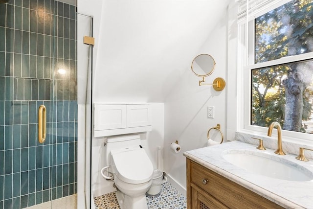 bathroom featuring vaulted ceiling, vanity, toilet, a shower with door, and tile patterned floors