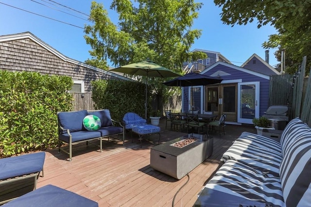 deck featuring an outdoor living space with a fire pit