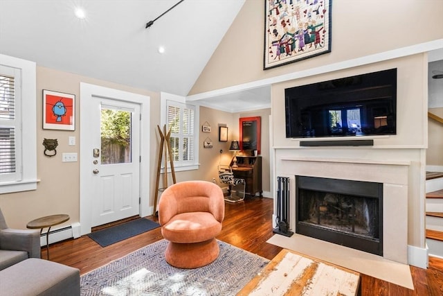 living room with vaulted ceiling, hardwood / wood-style floors, and a baseboard heating unit