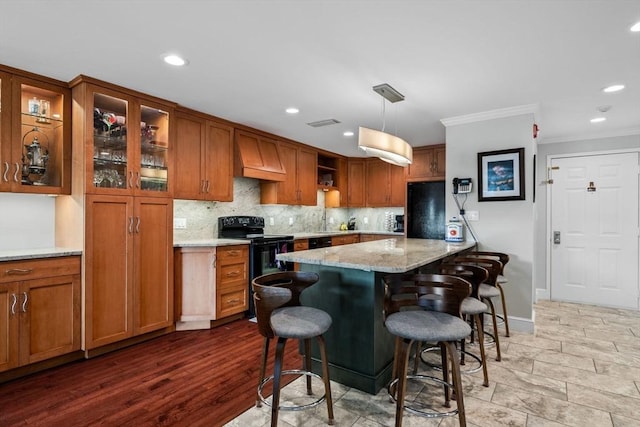 150 Lynnway Unit 406, Lynn, MA 01902 - kitchen featuring black / electric stove, brown cabinets, ornamental molding, fridge, and tasteful backsplash
