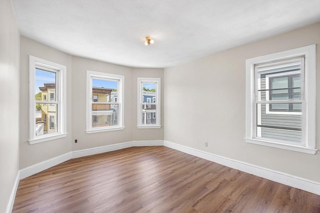 spare room with wood finished floors and baseboards