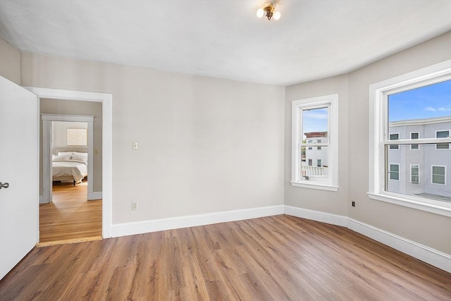 spare room with wood finished floors and baseboards
