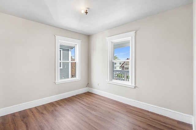 spare room with wood finished floors and baseboards