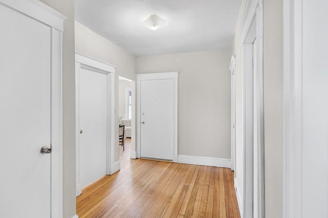 corridor featuring light wood-style floors and baseboards