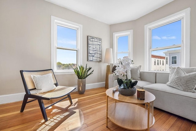 sitting room featuring healthy amount of natural light, baseboards, and light wood-style floors