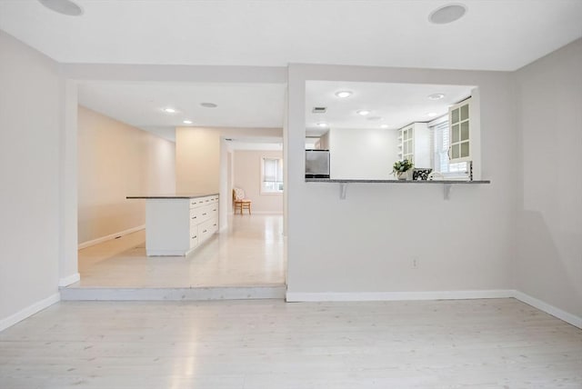 empty room with a healthy amount of sunlight and light hardwood / wood-style flooring