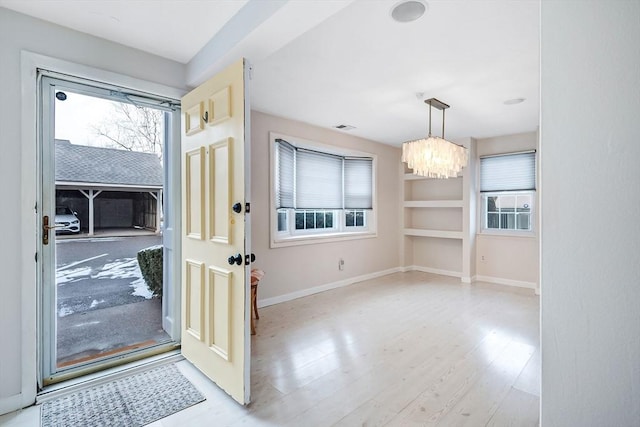 foyer entrance featuring an inviting chandelier and light wood-type flooring