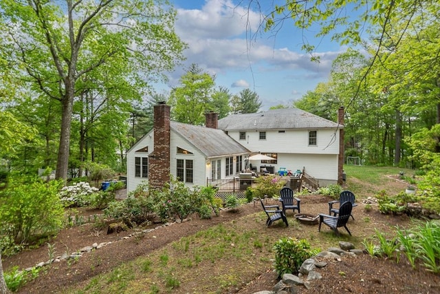 4 Rockwood Ln, Londonderry, NH 03053 - rear view of house with a fire pit and a chimney