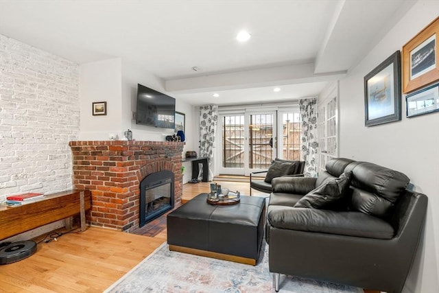 69 Saint Botolph Unit 1, Boston, MA 02116 - living room with wood finished floors, a brick fireplace, brick wall, and recessed lighting