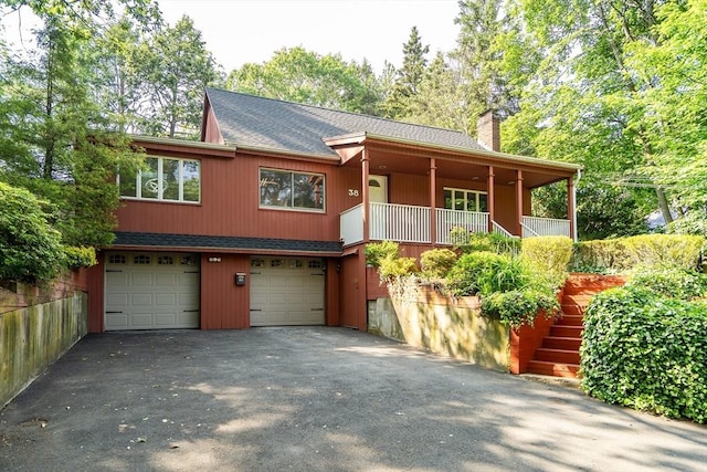 38 Maple St, Lexington, MA 02420 - view of front facade with a chimney, an attached garage, asphalt driveway, a shingled roof, and stairway