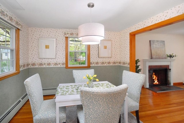 95 Bayberry Rd, Concord, MA 01742 - dining room featuring wallpapered walls, a baseboard radiator, wood finished floors, wainscoting, and a fireplace