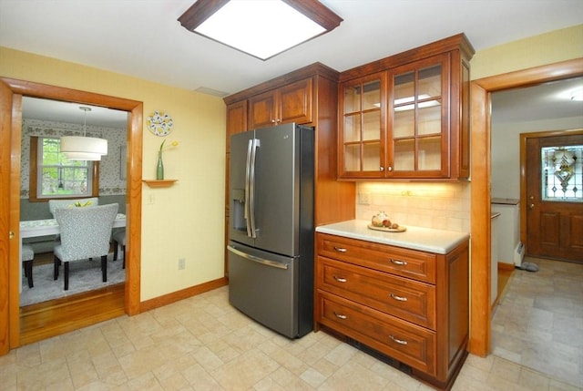95 Bayberry Rd, Concord, MA 01742 - kitchen with stainless steel refrigerator with ice dispenser, light countertops, glass insert cabinets, brown cabinetry, and backsplash