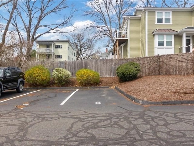 uncovered parking lot featuring fence
