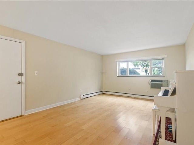 empty room featuring light wood-style flooring, a wall mounted AC, baseboards, and baseboard heating