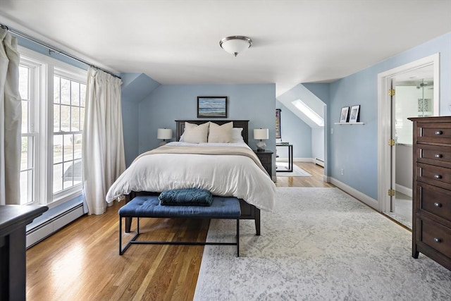 bedroom with a baseboard radiator, baseboards, and wood finished floors